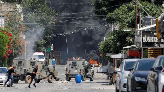 Palestinians run for cover during clashes with Israeli forces amid an Israeli military operation in Jenin, in the West Bank July 3, 2023.