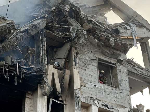 A firefighter looks out of a building impacted by Israeli strikes, Tehran, Iran, June 14, 2025