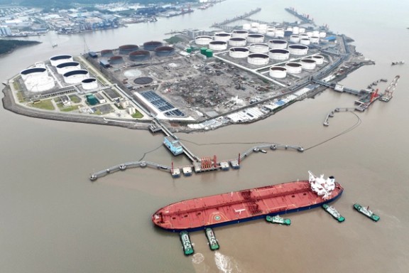 An aerial view shows tugboats helping a crude oil tanker to berth at an oil terminal, off Waidiao Island in Zhoushan, Zhejiang province, China July 18, 2022.