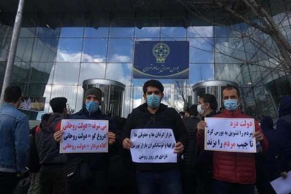 Small investors protesting outside Tehran stock exchange in 2021, holding signs calling the government "a thief".