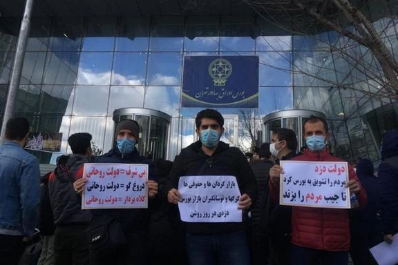 Small investors protesting outside Tehran stock exchange in 2021, holding signs calling the government "a thief".