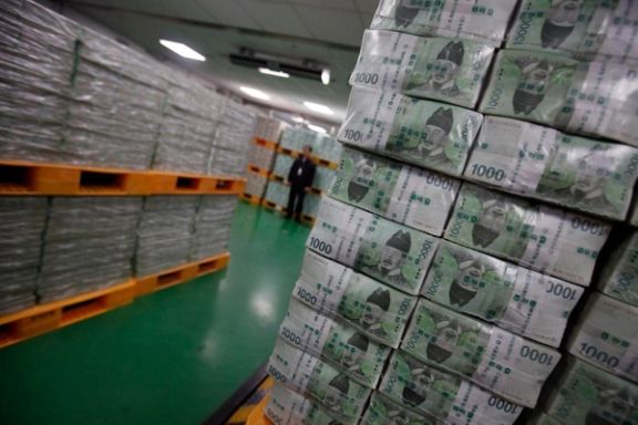 An employee from the Bank of Korea stands in front of stacks of South Korean won at the Bank of Korea's headquarters in Seoul.