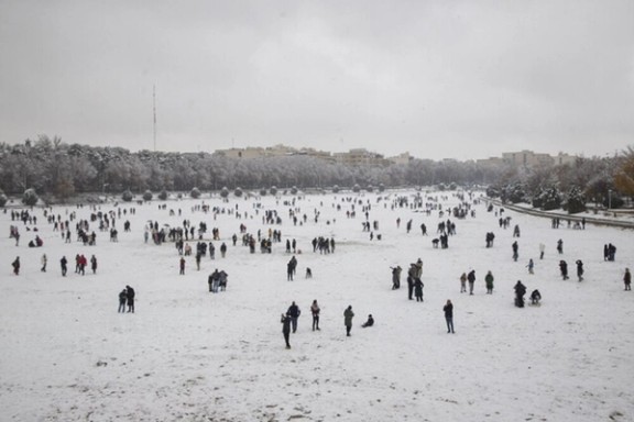 People walk across the snow-covered bed of the dried rive Zayandeh Roud in Isfahan after the season’s first snowfall, Iran, December 16, 2025