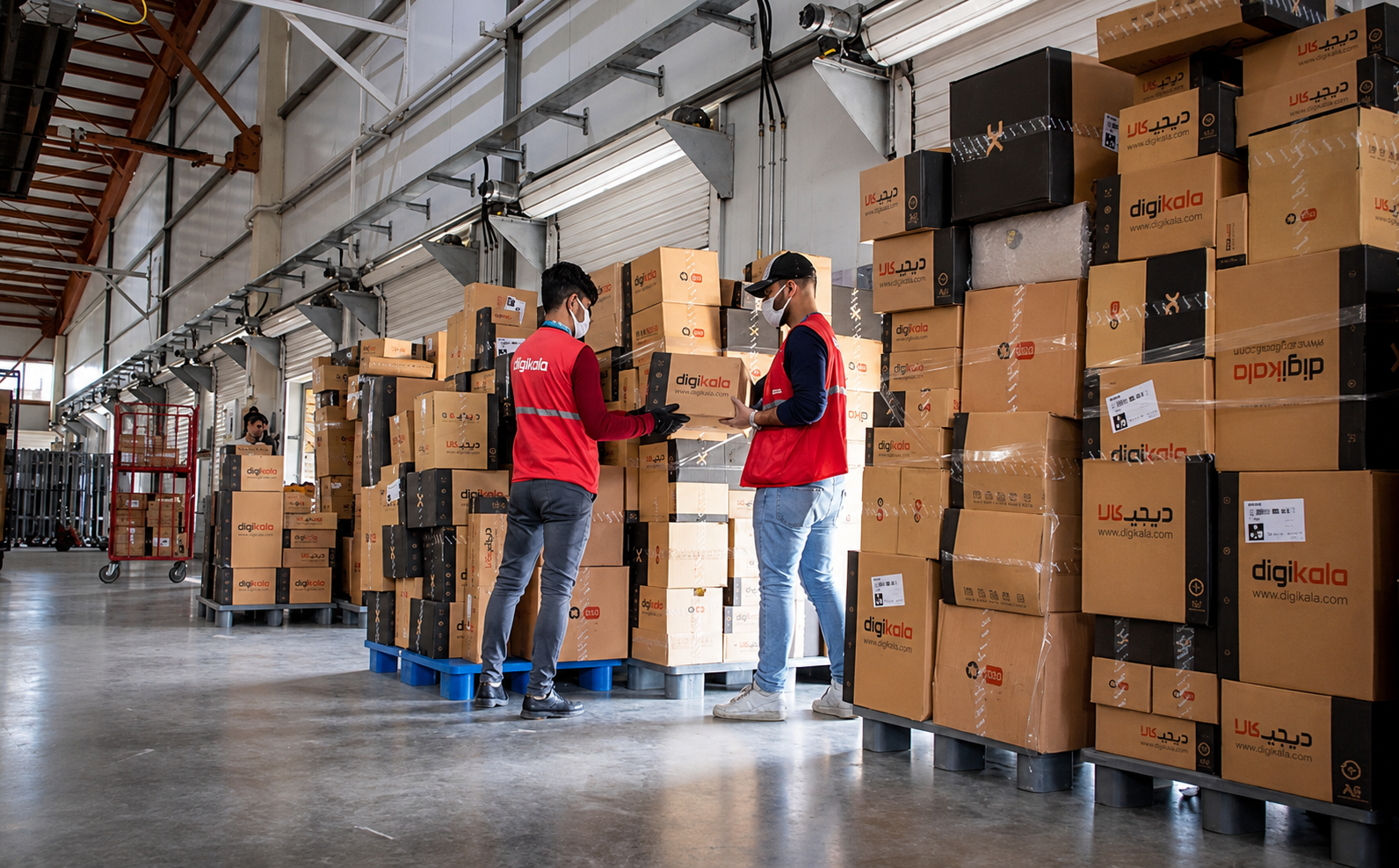 Workers handle packages at a Digikala warehouse in Iran.