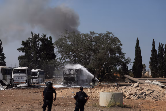 Emergency personnel spray water on a bus following a missile attack from Iran, in Herzliya, Israel, June 17, 2025.