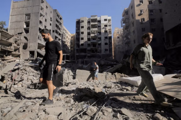 People walk on the rubble at the site of the Israeli airstrike that killed Lebanon's Hezbollah leader Sayyed Hassan Nasrallah on Friday, in Beirut's southern suburbs, Lebanon, September 29, 2024.