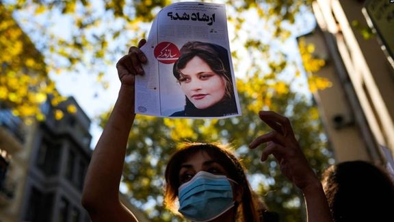 A protester holding up a poster of Mahsa Amini who was killed by Iran's "morality police"