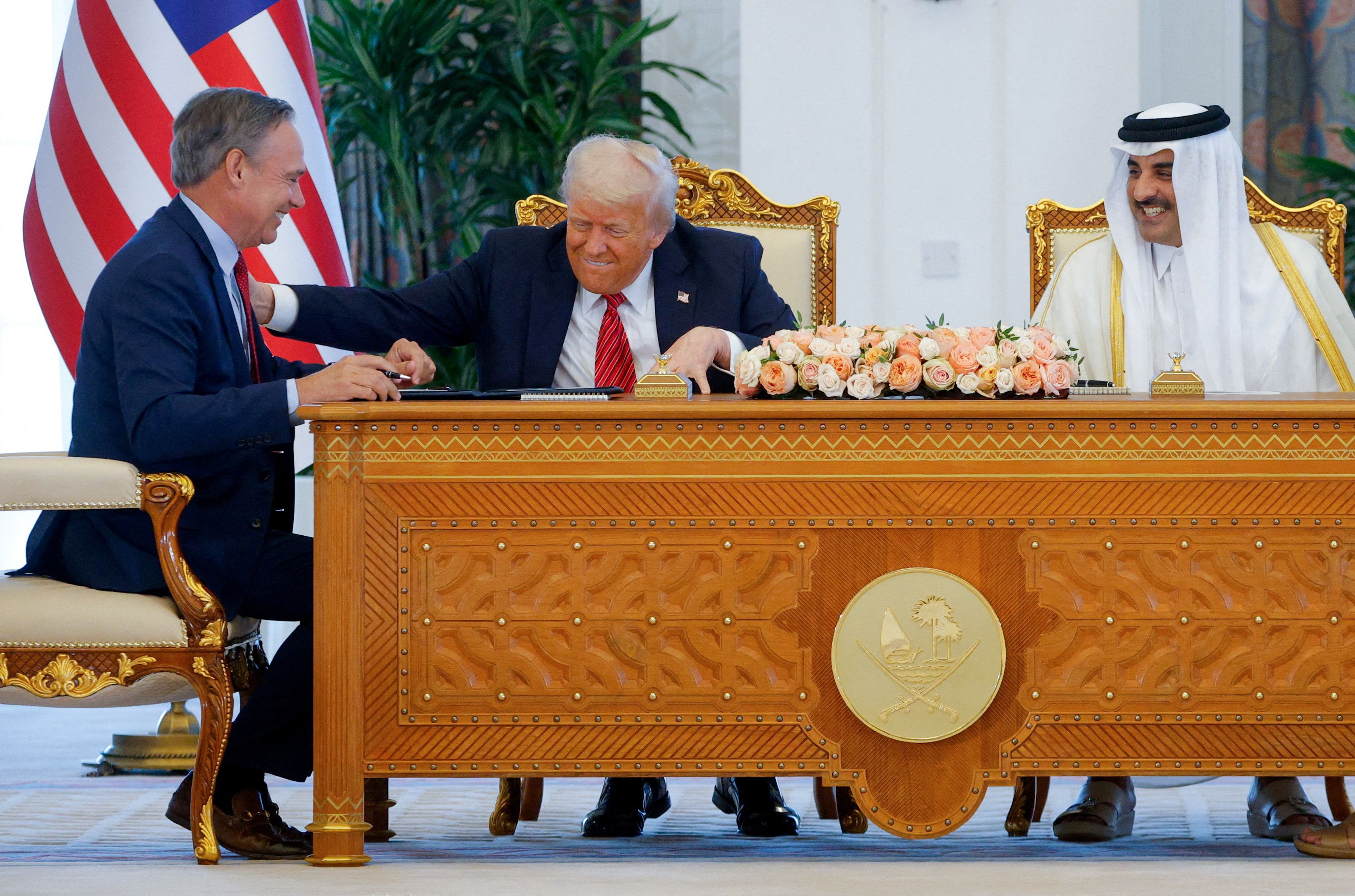 US President Donald Trump, Qatar's Emir Tamim bin Hamad Al Thani and Boeing CEO Kelly Ortberg attend a signing ceremony in Doha, Qatar, May 14, 2025. 