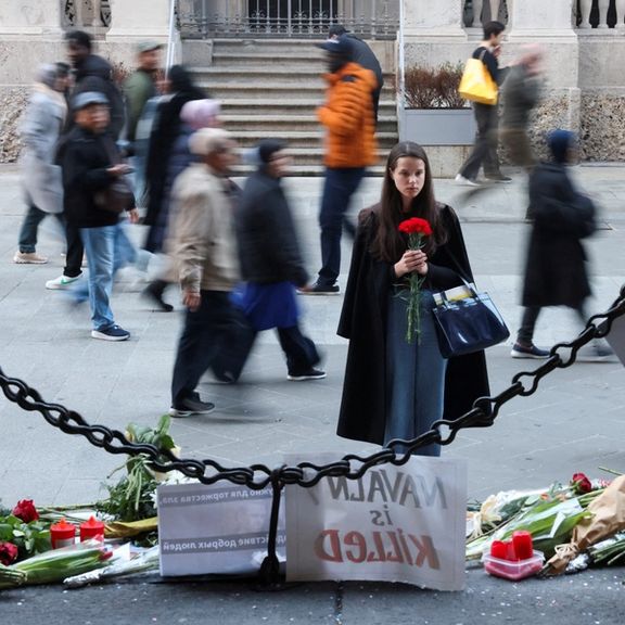 A woman holds flowers in front of a makeshift memorial to Russian opposition leader Alexei Navalny in Milan, Italy, February 19, 2024.