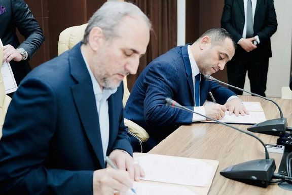 National Iranian Gas Company CEO Majid Chegeni (left) and Iraq's Ministry of Electricity Ziad Ali Fadhel signing a five-year barter deal in Baghdad on March 27, 2024