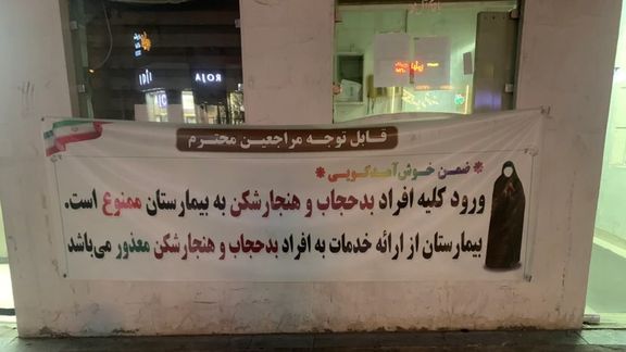A sign outside a hospital in Iran says no medical care for women with "bad hijab", July 2023