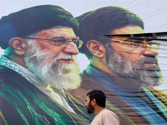 A man walks past a billboard featuring the portraits of Iran's new Supreme Leader Ayatollah Mojtaba Khamenei (right) and the late Supreme Leader Ayatollah Ali Khamenei (left) in Srinagar, Jammu and Kashmir, on June 15, 2026.