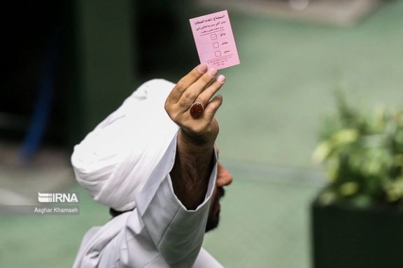 A lawmaker voting to impeach Industry Minister Reza Fatemi-Amin on April 30, 2023