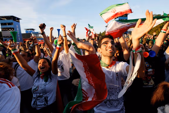 Supporters of Iran celebrate while watching the match in a fan zone.