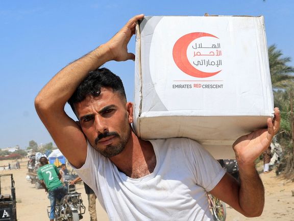 یک فلسطینی بسته مواد غذایی پرتابشده از هواپیما را حمل میکند؛ مرکز نوار غزه، ششم مرداد