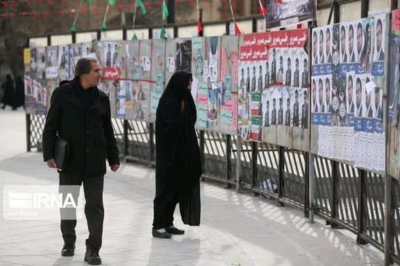 Iranians looking at the election campaign posters of the candidates of the country’s parliamentary elections