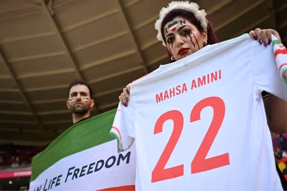 Two Iranian fans holding a jersey in memory of Mahsa Amini at 2022 Qatar World Cup