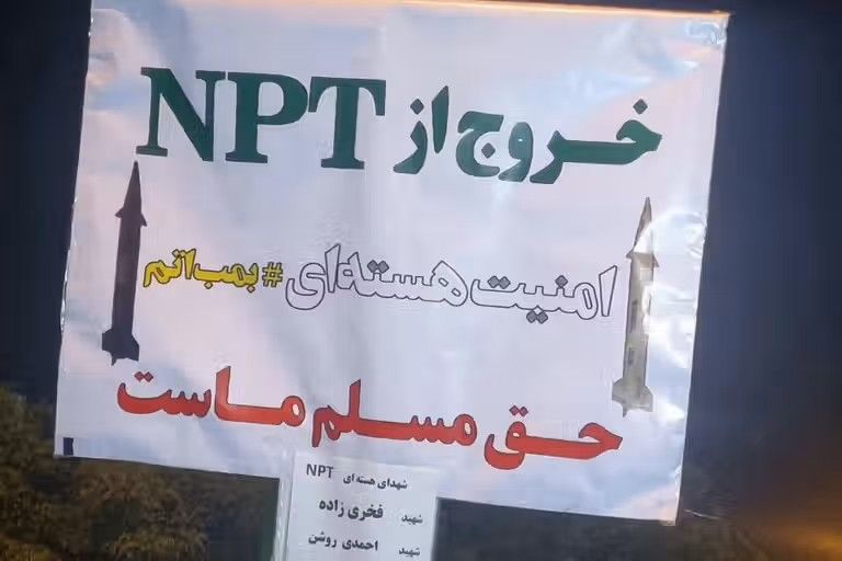 A placard printed by Iranian hardliners reads: “Withdrawing from the NPT is our inalienable right. Nuclear security = atomic bomb.”