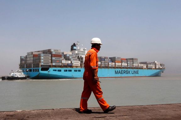 A worker walks past a container ship at Mundra Port in the western Indian state of Gujarat April 1, 2014.