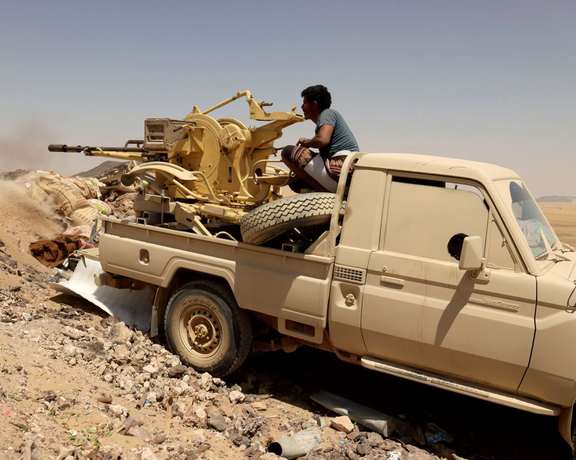 A fighter firing a machinegun in Yemen civil war.