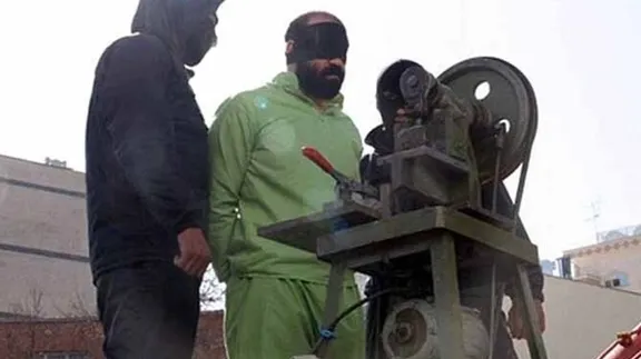 A prisoner about to be amputated by a guillotine-like device