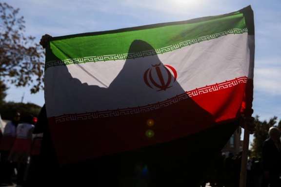 A woman holds up an Iranian flag in a state-sponsored rally in Tabriz, Iran, November 4, 2025