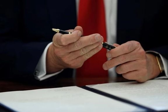 President Donald Trump prepares to sign an executive order at his desk in the Oval Office at the White House, February 24, 2017.