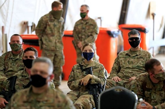 US soldiers wearing protective masks are seen during a handover ceremony of Taji military base from US-led coalition troops to Iraqi security forces, in the base north of Baghdad, Iraq August 23, 2020.