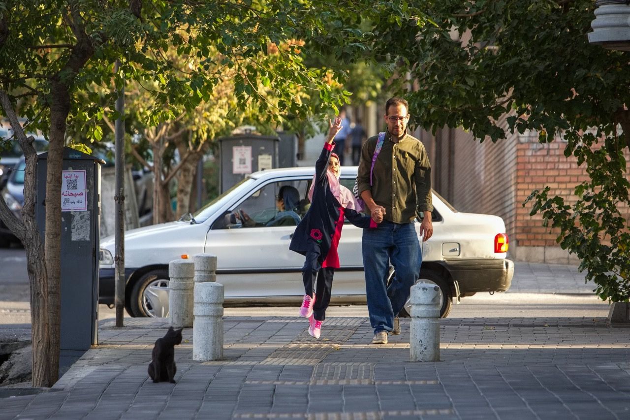 A father and daughter walk together on a street in Tehran, Iran, September 23, 2026
