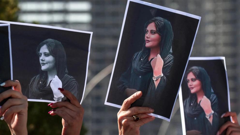 Protestors holding up Mahsa Amini's picture at a rally