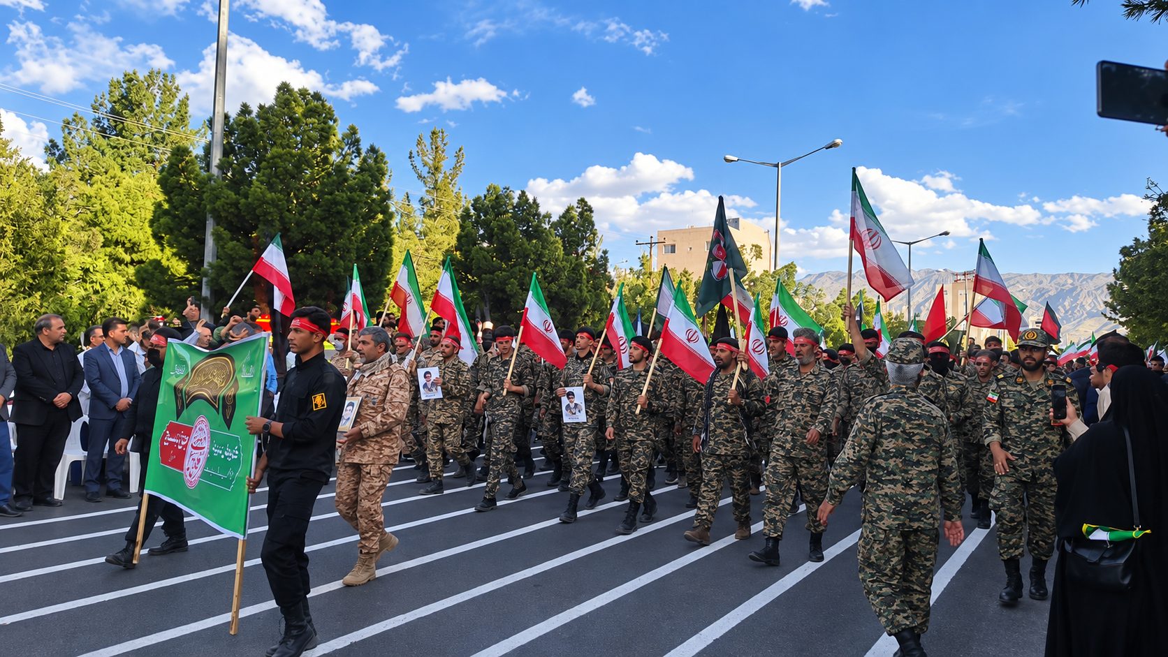 Basij forces march carrying Iranian flags during a parade in Iran.
