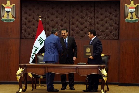 Iraq's National Security Adviser Qasim al-Araji looks on as Iraqi Prime Minister Mohammed Shia al-Sudani greets Iran's Supreme National Security Council secretary Ali Shamkhani during a signing of the security agreement that includes coordination in protecting the common borders between the two countries, in Baghdad, Iraq, March 19, 2023.
