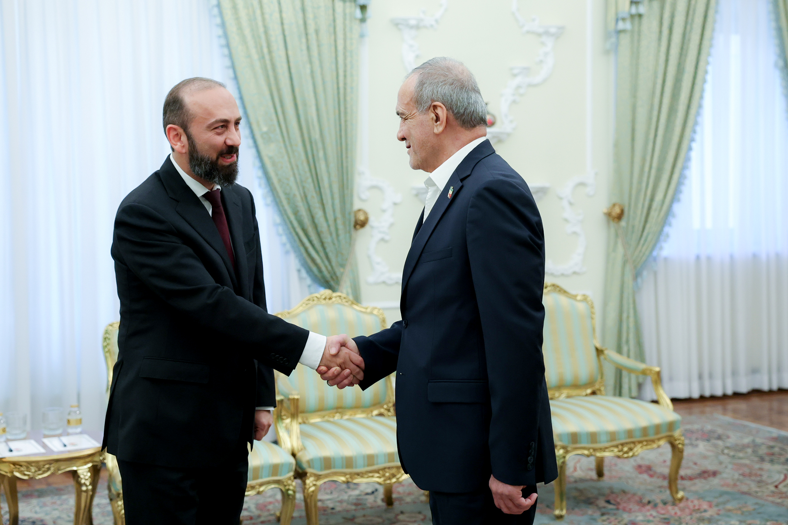 Iran's President Masoud Pezeshkian shakes hands with Armenia's foreign minister in Tehran on Oct. 5