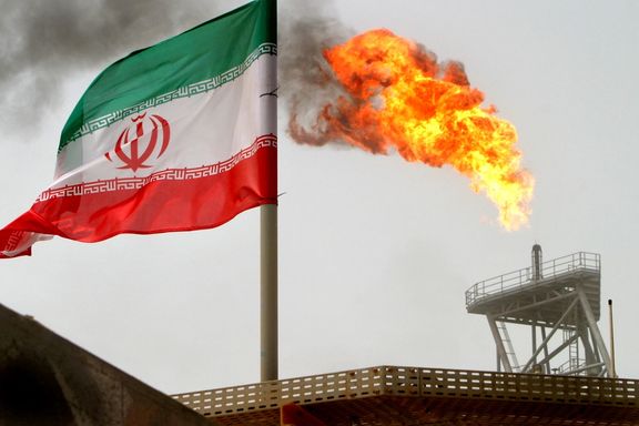 A gas flare on an oil production platform is seen alongside an Iranian flag in the Persian Gulf July 25, 2005.