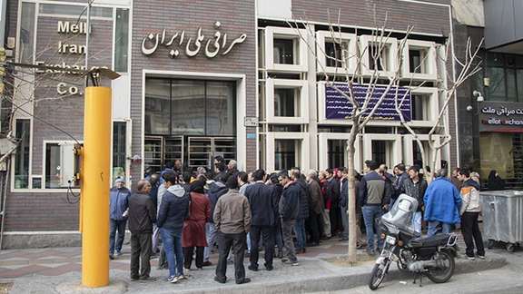People gathered outside a bank foreign exchange office in Tehran. Undated