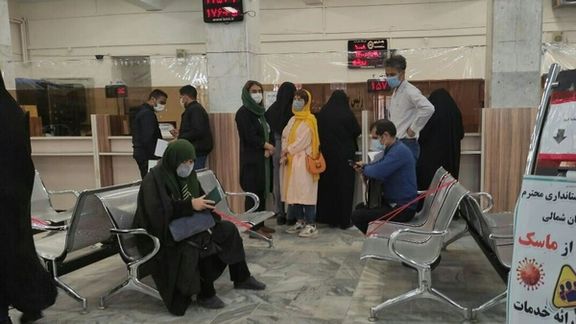 People stand in a line inside a bank