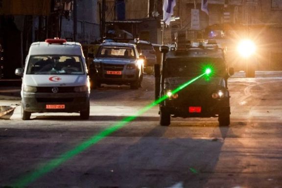An Israeli military vehicle uses a laser, on the day of an Israeli raid in Jenin, in the Israeli-occupied West Bank, January 21, 2025.
