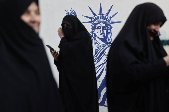 Women gather next to an anti-US mural, showing the Statue of Liberty with a severed arm, during the rallies in Tehran, November 4, 2025.