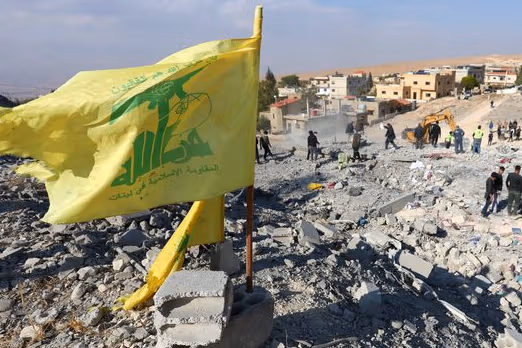 A Hezbollah flag flutters at a site damaged in the aftermath of an Israeli strike on the town of Al-Ain in the Baalbek region, in Lebanon, November 6, 2024