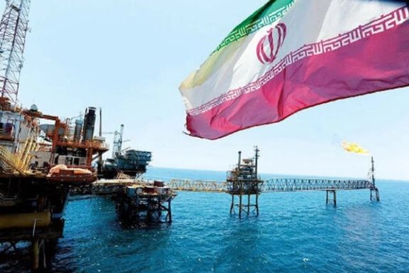 An offshore oil platform in Iran with the Iranian flag displayed in the foreground