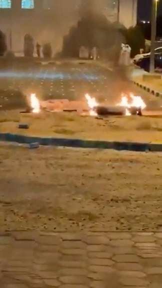 Debris burns on the ground in a parking lot following reports of missile and drone attacks, in Sabah Al Nasser, Kuwait on June 3, 2026, in this screengrab obtained from a social media video.