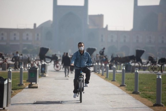 An Iranian man cycles while wearing a mask in the city of Isfahan, November 2025.