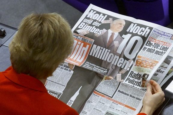 An unidentified member of the Bundestag lower house of parliament reads the front page of Germany's biggest daily newspaper "Bild" in Berlin. (file photo)