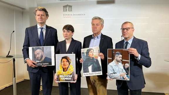 Members of the Austrian parliament holding photos of Iranian protesters in danger of execution