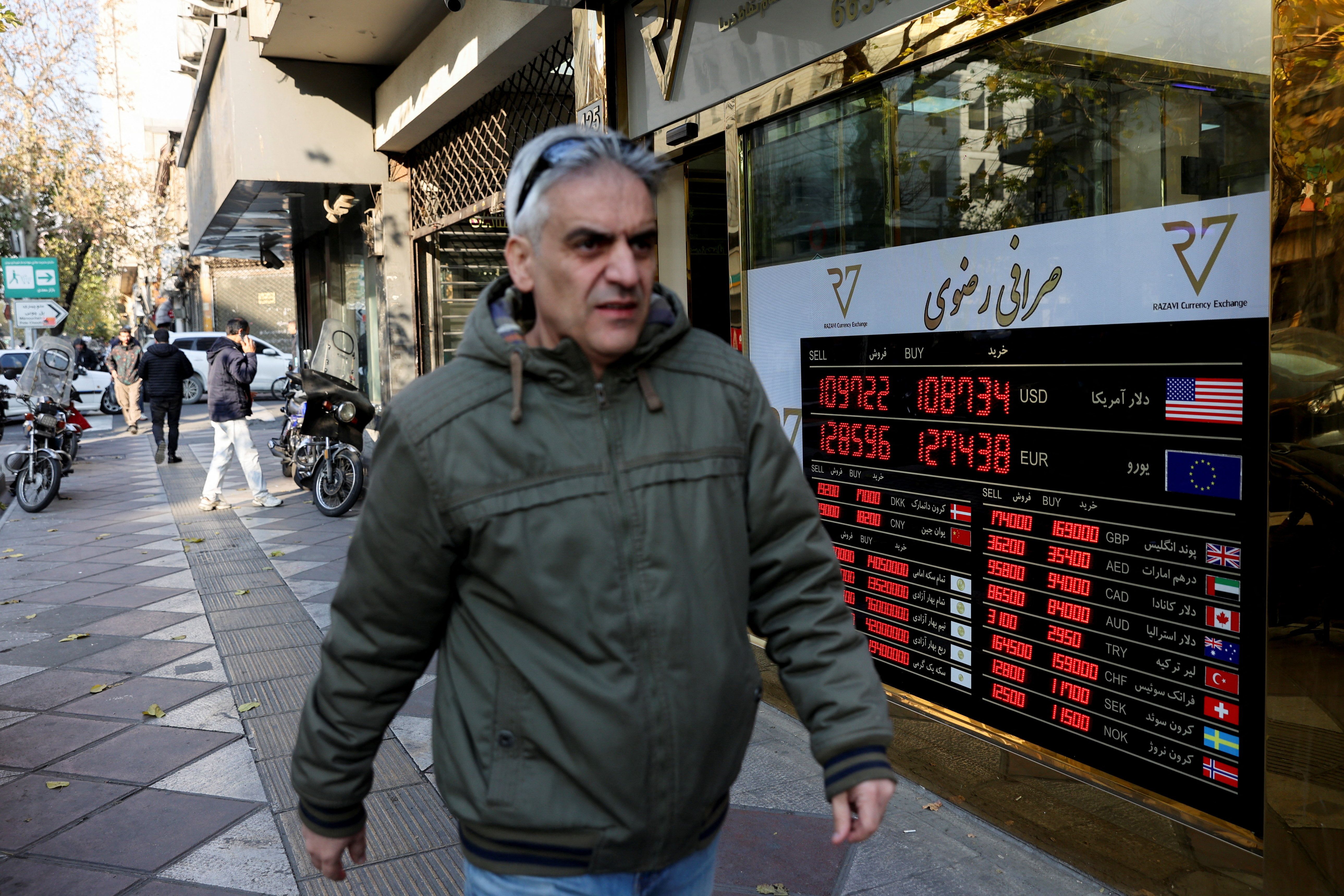 A man walks past a sign at a currency exchange bureau as the value of the Iranian rial drops, in Tehran, Iran, December 20, 2025.