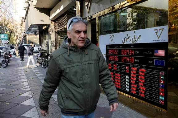 A man walks past a sign at a currency exchange bureau as the value of the Iranian rial drops, in Tehran, Iran, December 20, 2025.