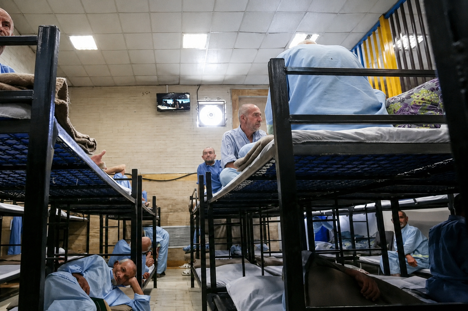 File photo of residents sitting on bunk beds inside an addiction treatment and rehabilitation camp in Iran.
