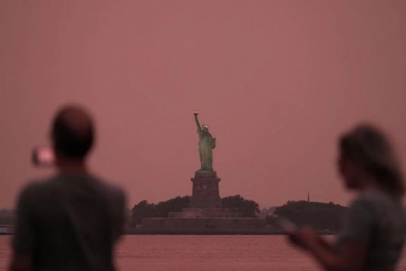 مردم مجسمه آزادی را از میان مه ناشی از دود آتشسوزیهای کانادا تماشا میکنند. نیویورک، ۶ اوت ۲۰۲۵
