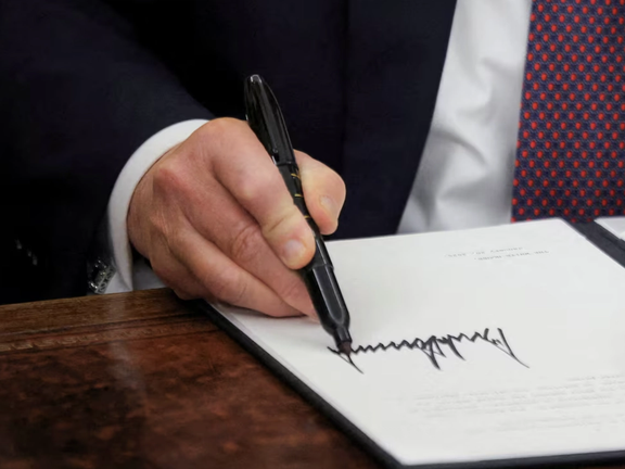 US President Donald Trump signs documents as he issues executive orders in the Oval Office at the White House on Inauguration Day in Washington, U.S., January 20, 2025