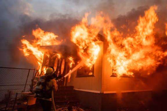 A firefighter battles the Palisades Fire as it burns during a windstorm on the west side of Los Angeles, California, US January 7, 2025.